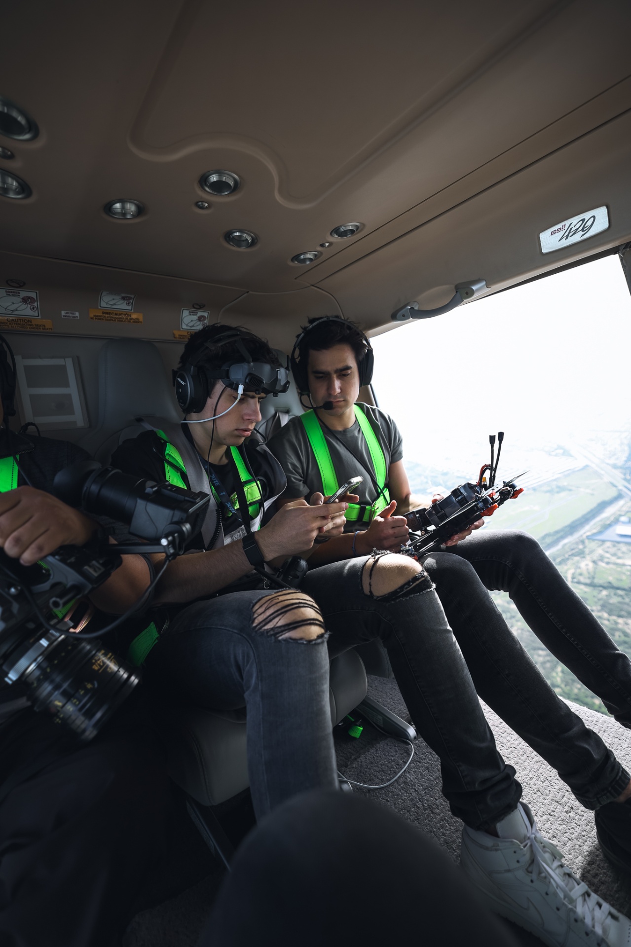 FPV pilot and spotter inside a Bell 429 helicopter prepping a cinelifter