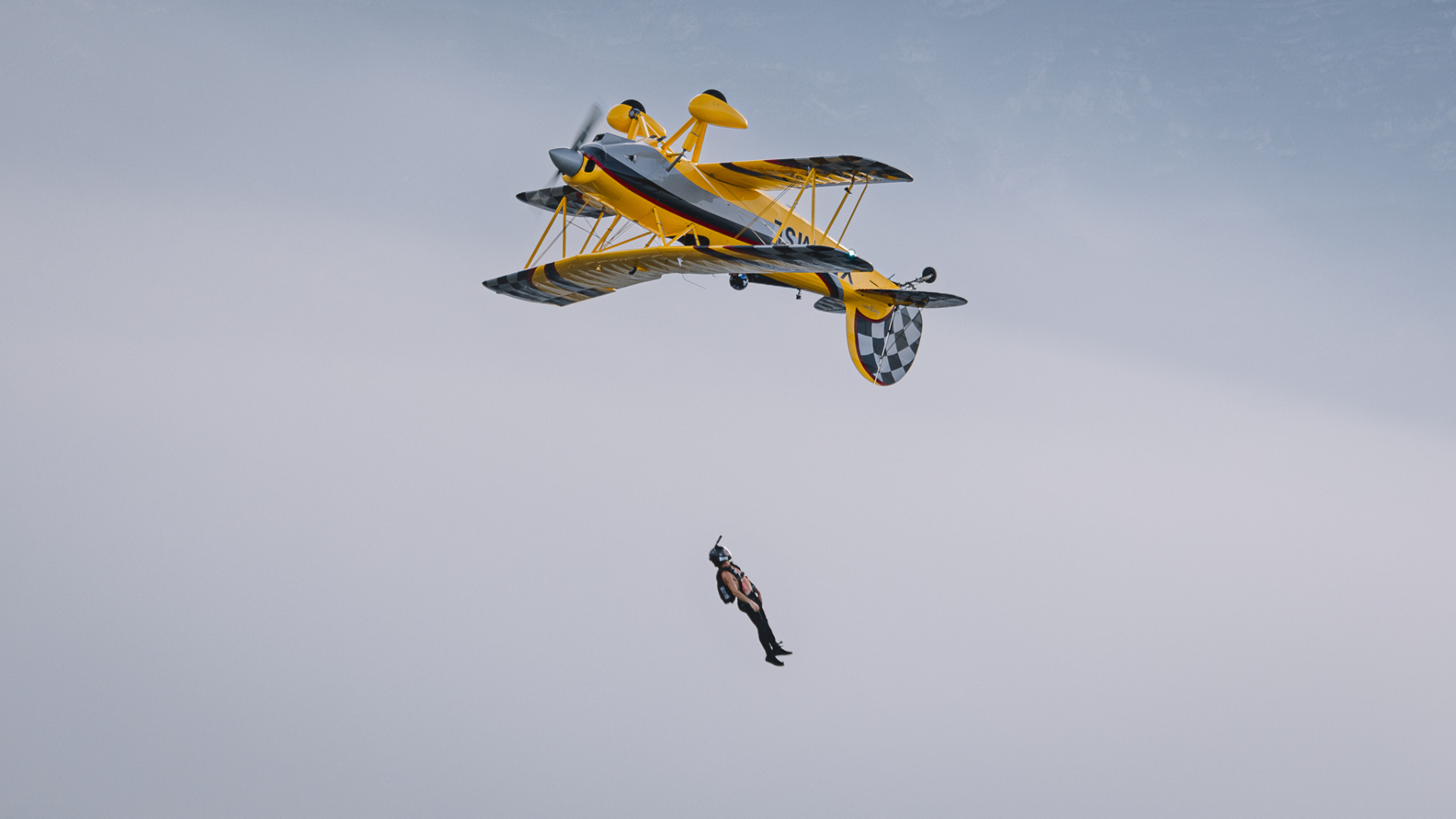 Wing walker in freefall just after releasing from biplane