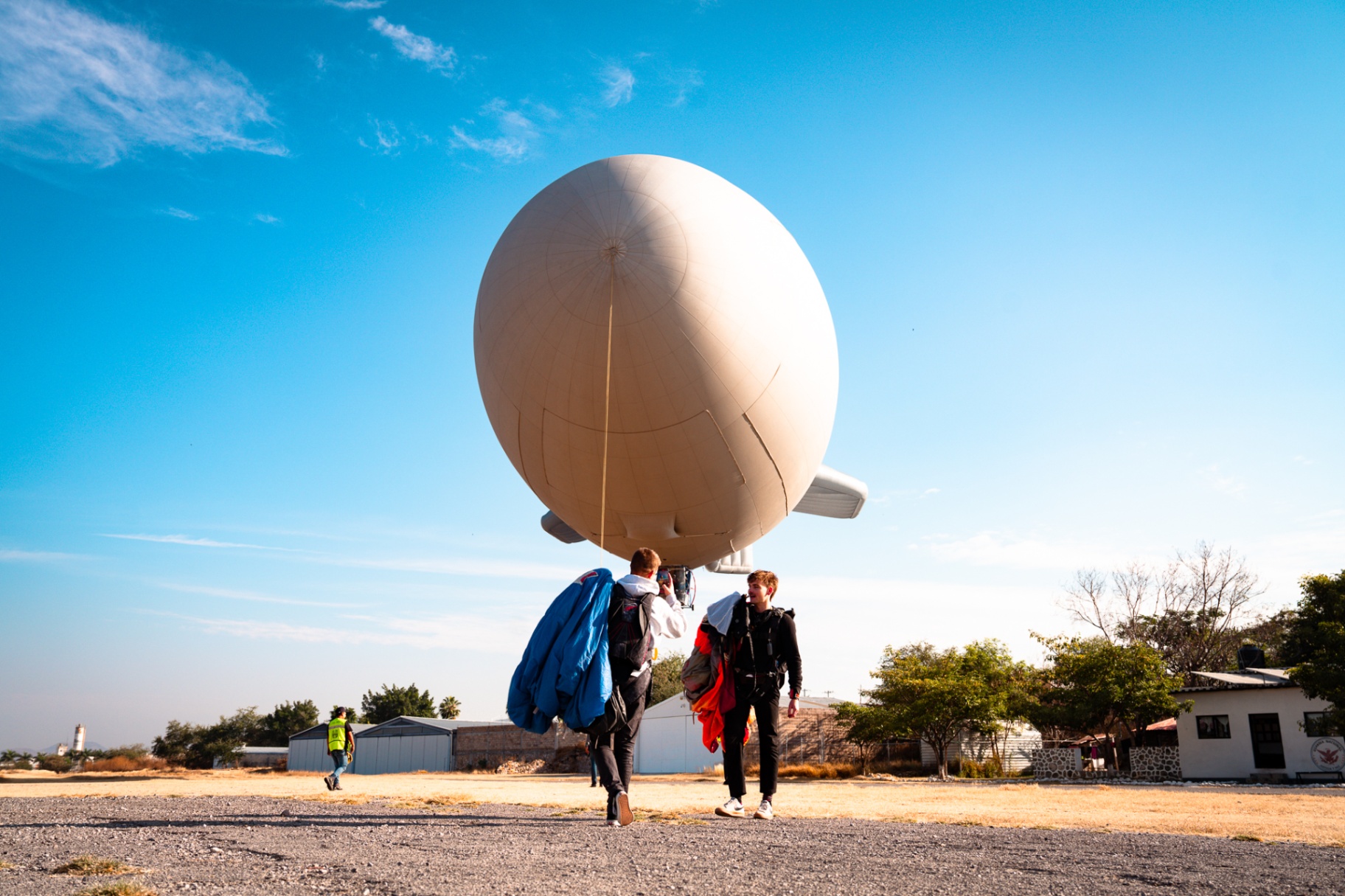 Two operators walking out to an inflated cinema airship on the runway